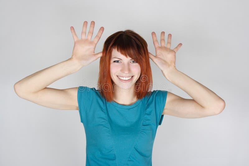 Woman smiling and teasing, opened palms near head