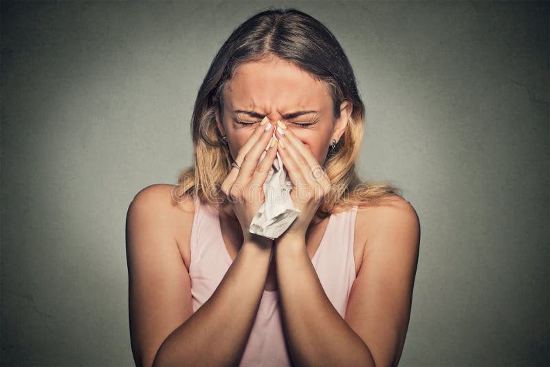 Woman sneezing blowing her runny nose