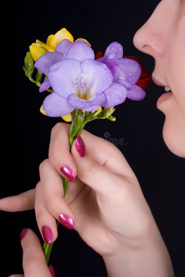 Woman sniffing flowers, freesia
