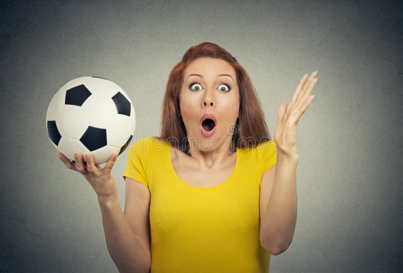 Surprise astonished woman. Closeup portrait woman with soccer ball looking surprised in full disbelief wide open mouth isolated grey wall background. Human emotion facial expression body. Funny girl. Surprise astonished woman. Closeup portrait woman with soccer ball looking surprised in full disbelief wide open mouth isolated grey wall background. Human emotion facial expression body. Funny girl