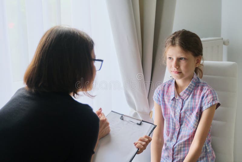 Woman social worker psychologist talking to girl child in office royalty free stock photos Woman social worker psychologist talking to girl child in office royalty free stock photos