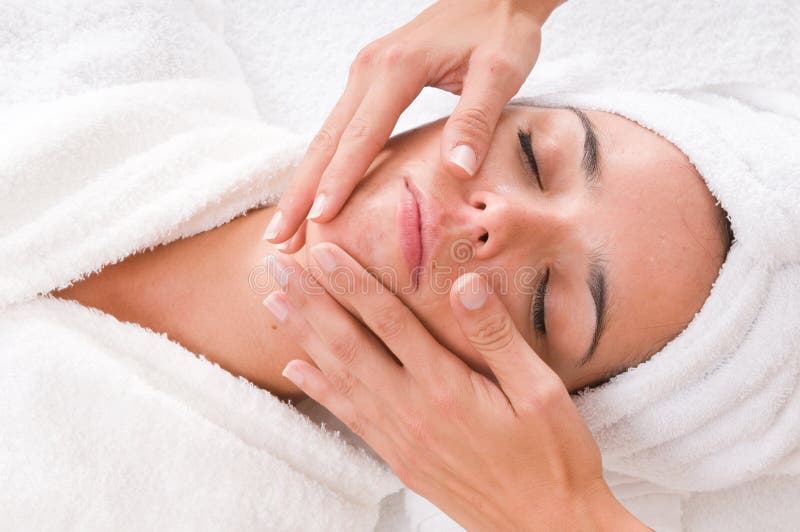 Woman in a spa is getting a massage on her face