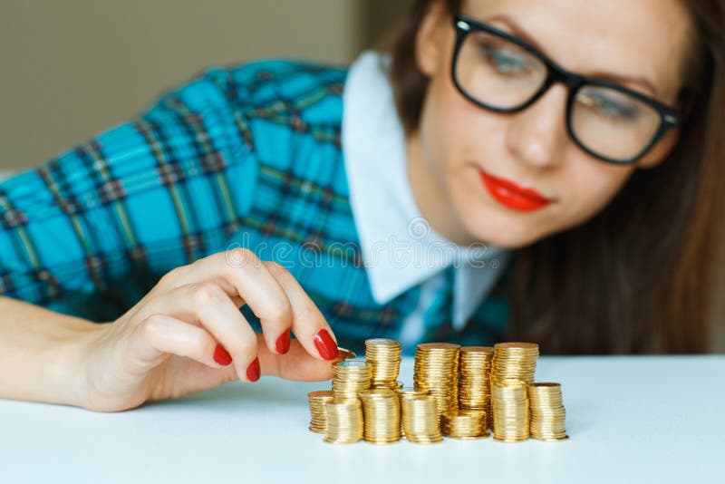 Woman stacking gold coins into columns