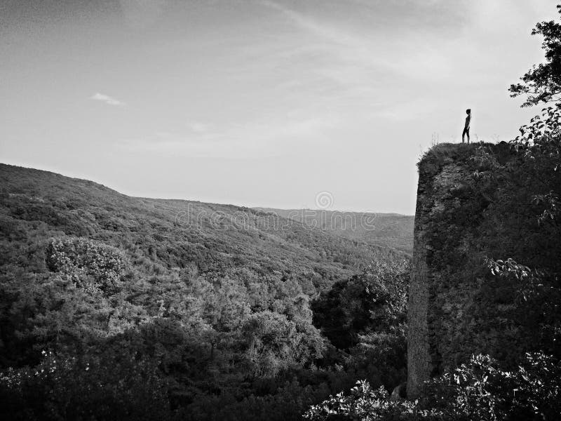 A Woman stand on a rock black and white