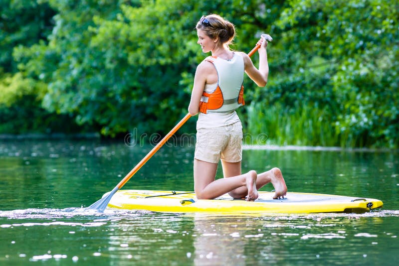 Woman with stand up paddle board sup on river