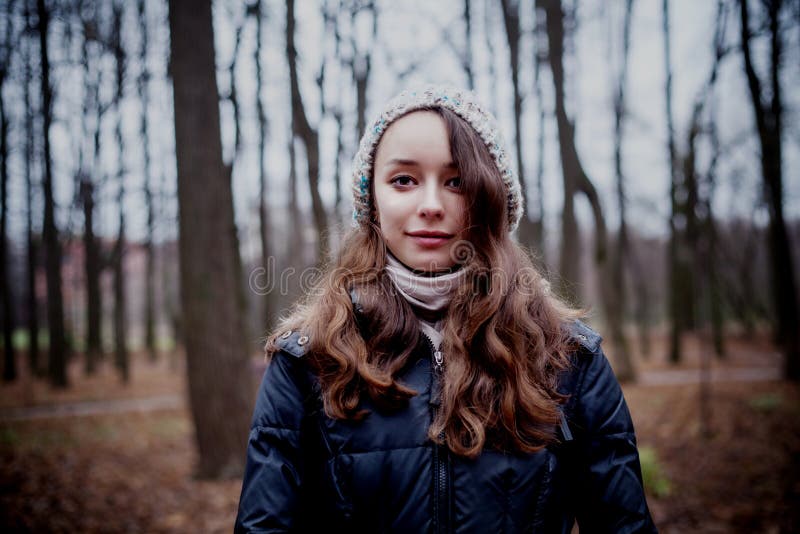 Woman standing in dark cold forest background