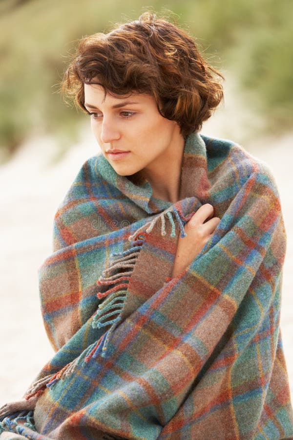 Woman Standing In Sand Dunes Wrapped In Blanket