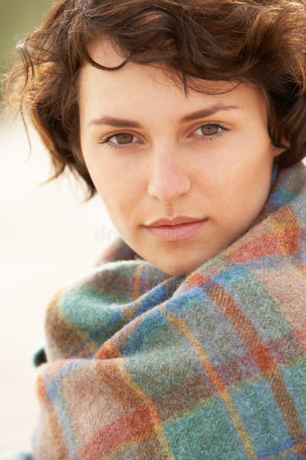 Woman Standing In Sand Dunes Wrapped In Blanket