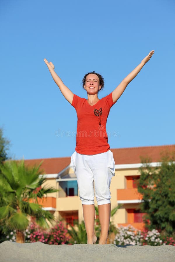 Woman stands and gladly lifts hands up