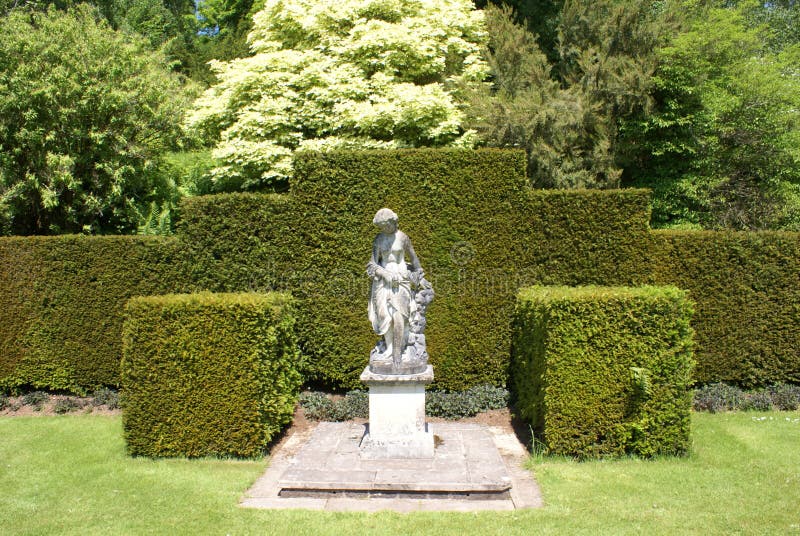 Woman statue. hedges. topiary trees