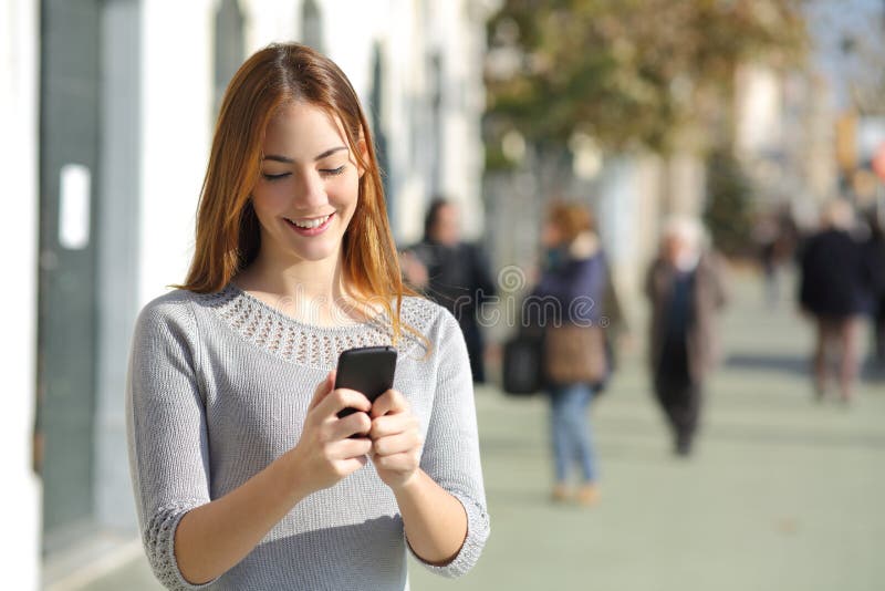 Portrét krásny ležérny žena v ulice prechádzanie chytrý telefón.