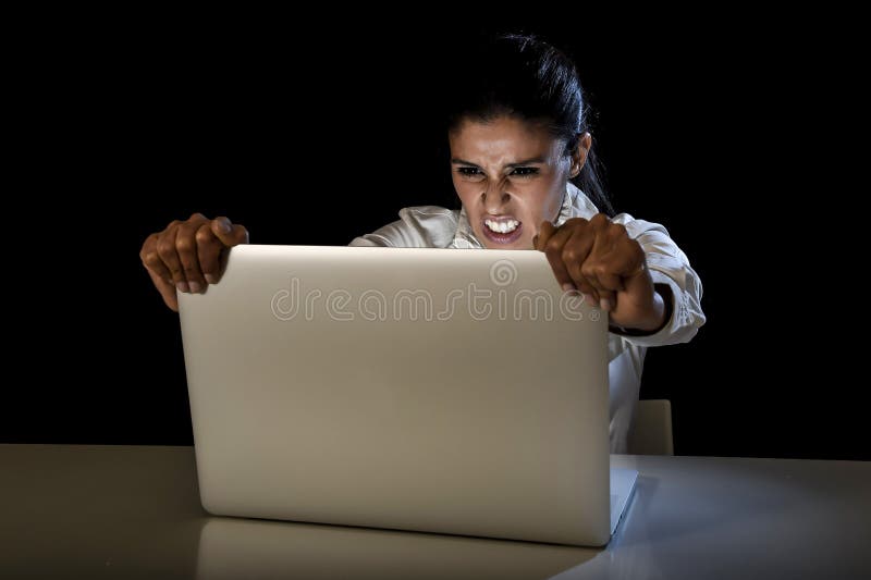 Woman or student girl working on laptop computer late at night holding the screen screaming