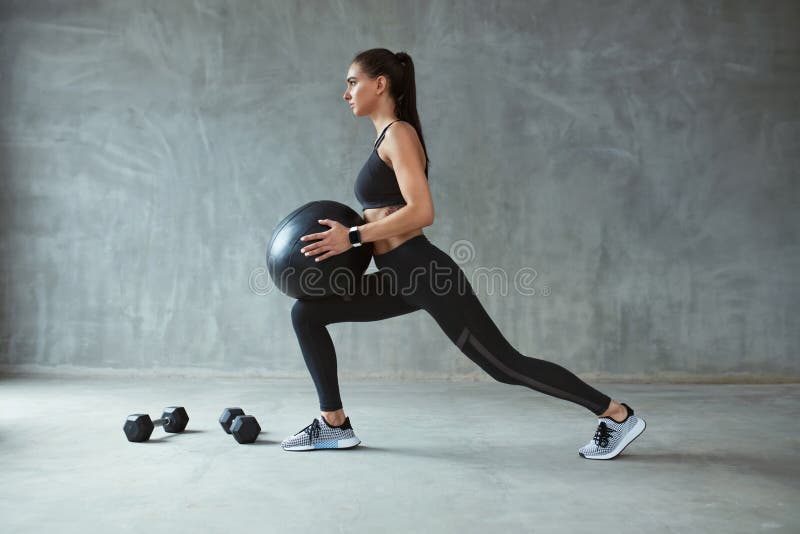 Woman in Stylish Sports Wear Training with Med Ball Stock Photo