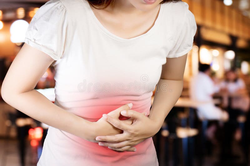 Woman suffer from stomachache or Gastroenterologist. Concept with Healthcare And Medicine. Pain in red color. Isolate with clipping path on blur restaurant stock photography Woman suffer from stomachache or Gastroenterologist. Concept with Healthcare And Medicine. Pain in red color. Isolate with clipping path on blur restaurant stock photography