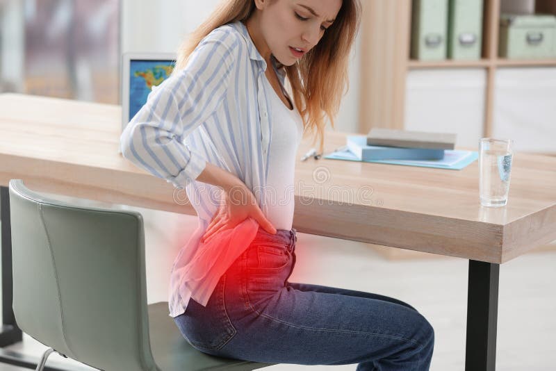 Woman Suffering from Back Pain in Office. Symptom of Bad Posture Stock