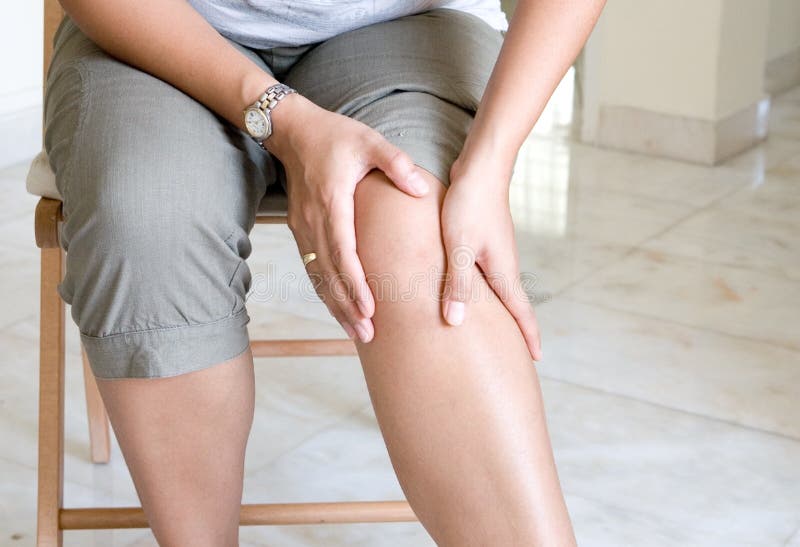 Woman massaging her painful knee. Woman massaging her painful knee