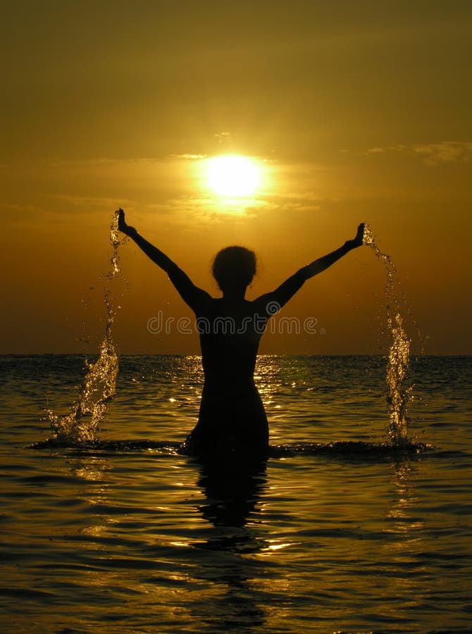 Woman at sunrise with drops of water