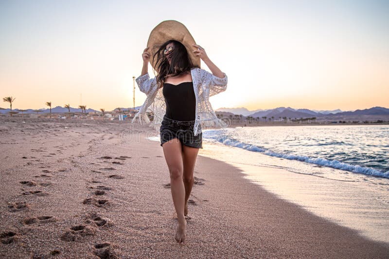 Woman at Sunset on the Beach in a Hat Stock Photo - Image of filtered ...