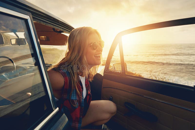 Woman, sunset and beach road trip by car door with smile, freedom and happiness for summer vacation. Happy gen z girl