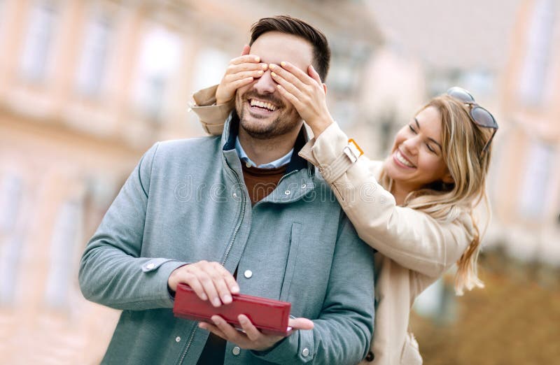 Woman surprising his boyfriend with a gift.