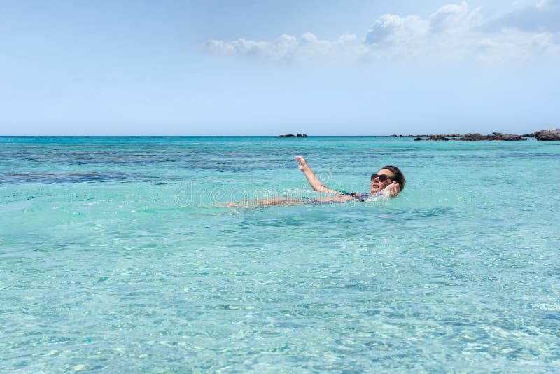 Woman swiming in the sea at Elafonisi beach, in the island of Cr