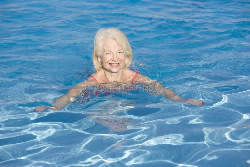 Woman swimming in outdoor pool smiling royalty free stock image Woman swimming in outdoor pool smiling royalty free stock image