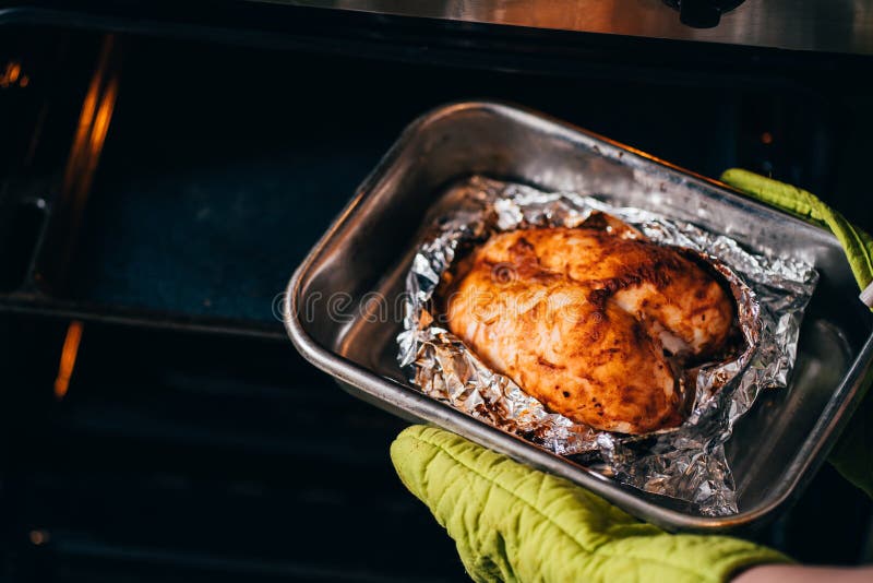 Woman Taking Baked Chicken Breasts from Oven Stock Photo - Image of ...