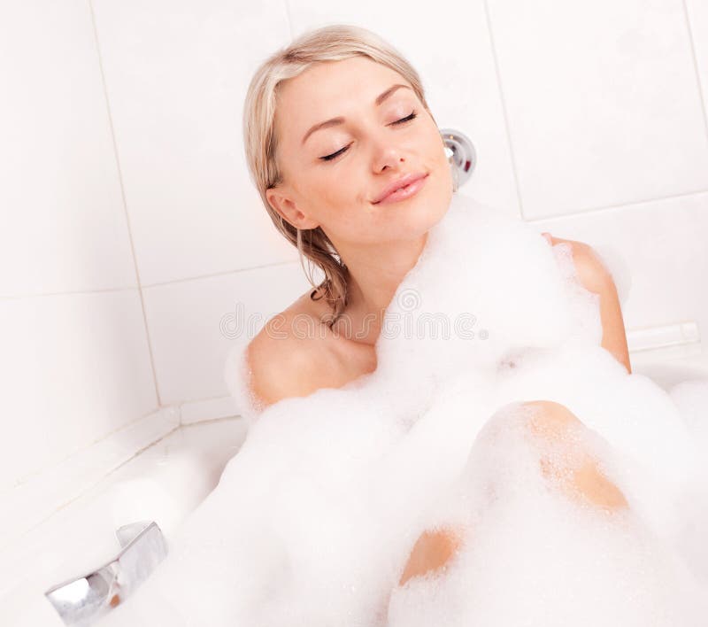 Beautiful young blond woman taking a relaxing bath with foam. Beautiful young blond woman taking a relaxing bath with foam