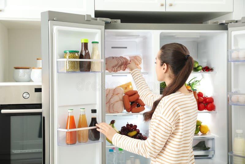 Woman Taking Ham Out of Refrigerator in Kitchen Stock Image - Image of ...