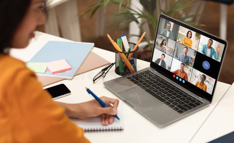 Woman Taking Notes During a Video Conference Meeting on Laptop royalty free stock photos