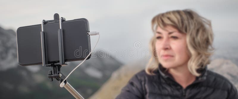 Woman taking panoramic picture of mountain landscape. Selfie photo stick stock photo Woman taking panoramic picture of mountain landscape. Selfie photo stick stock photo