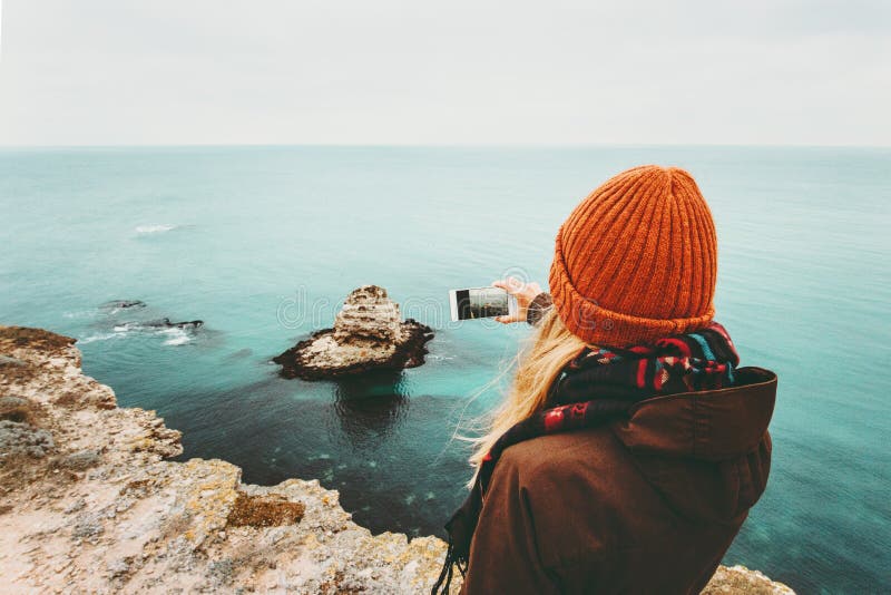 Woman taking photo by smartphone of sea landscape stock image Woman taking photo by smartphone of sea landscape stock image