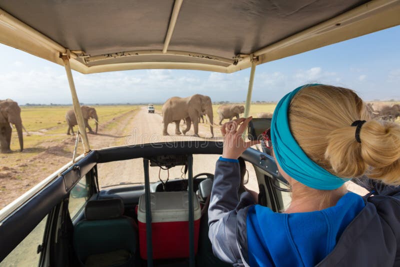 Woman taking photos on african wildlife safari. Amboseli, Kenya.