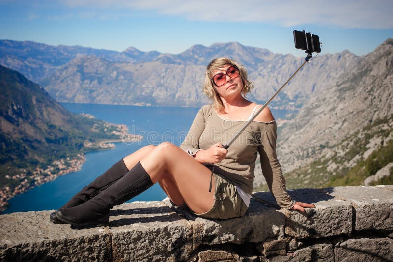 Woman taking selfie picture on landscape background using photo stock photos Woman taking selfie picture on landscape background using photo stock photos