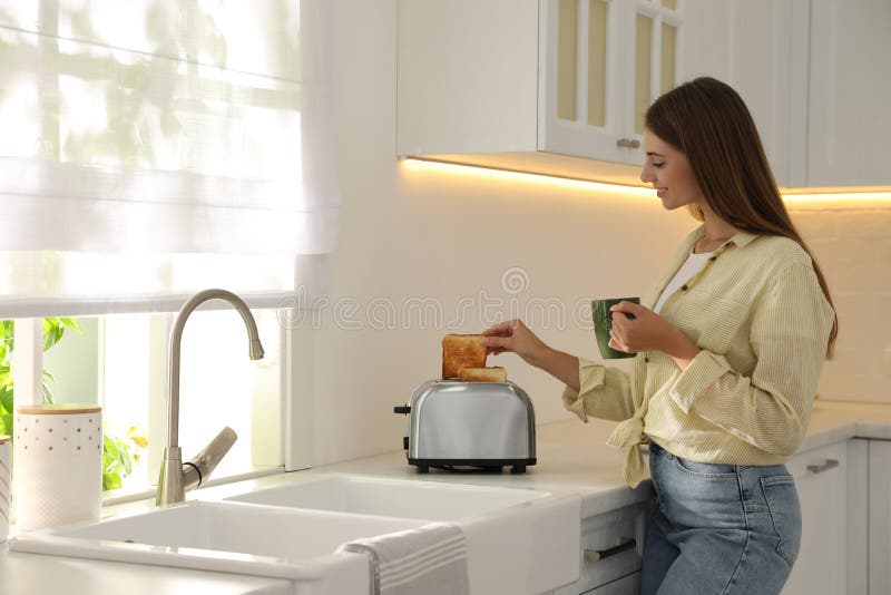 Young Woman Taking Slice of Bread from Toaster in Kitchen Stock Image Image of device, drink