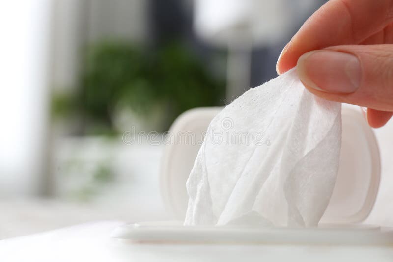 Woman taking wet wipe from pack on background, closeup