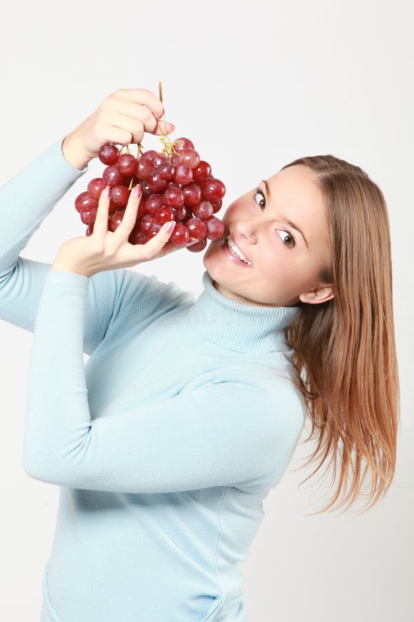 Woman tasting red grapes