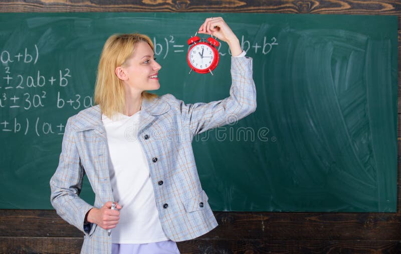 Woman teacher hold alarm clock. She cares about discipline. Time to study. Welcome teacher school year. Looking.