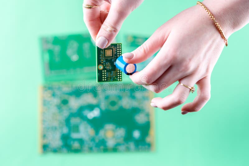 The woman technician is assembling a capacitor on the Circuit Board. Computer, service, repairing and technology. royalty free stock photos