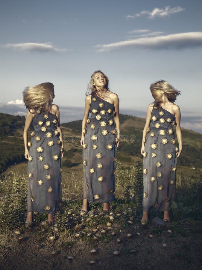 Una donna bionda colpo in uno scenario naturale di una collina, in pieno giorno.