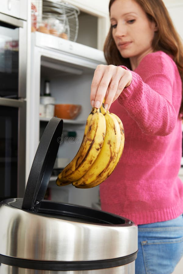 Woman Throwing Away Out of Date Food in Refrigerator Stock Photo