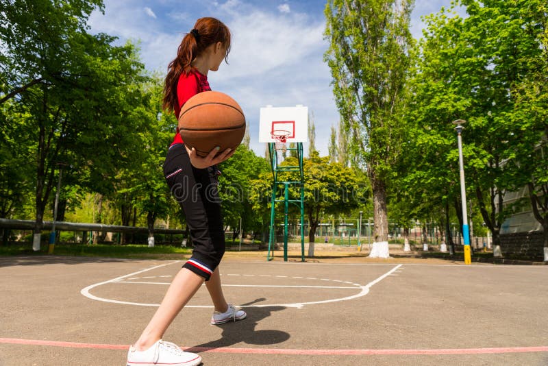 Woman Throwing Basketball from Top of Court Key