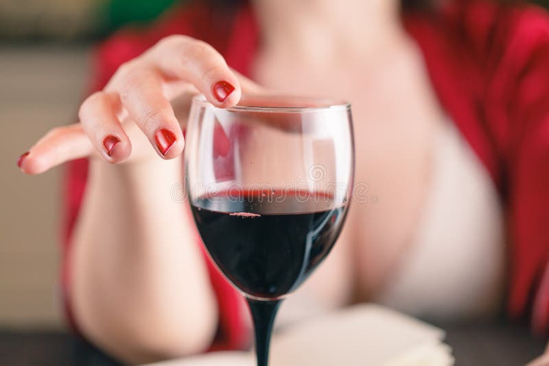 Woman touching glass of red wine and using his laptop