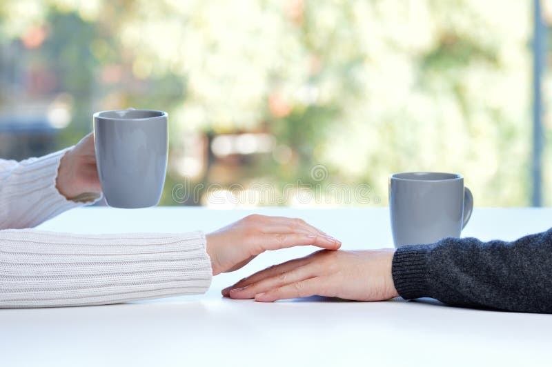 woman touching the hand of her partner during a date in a table of a coffee shop or home royalty free stock images woman touching the hand of her partner during a date in a table of a coffee shop or home royalty free stock images