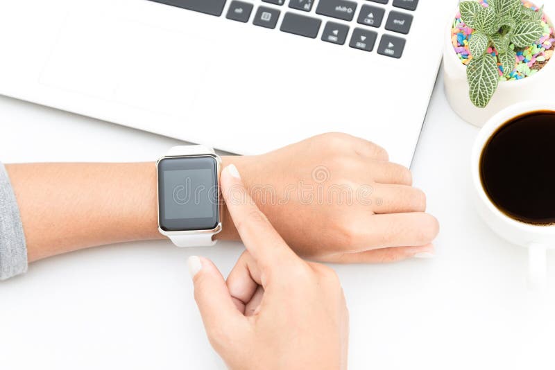 Woman touching smart watch hand on work table