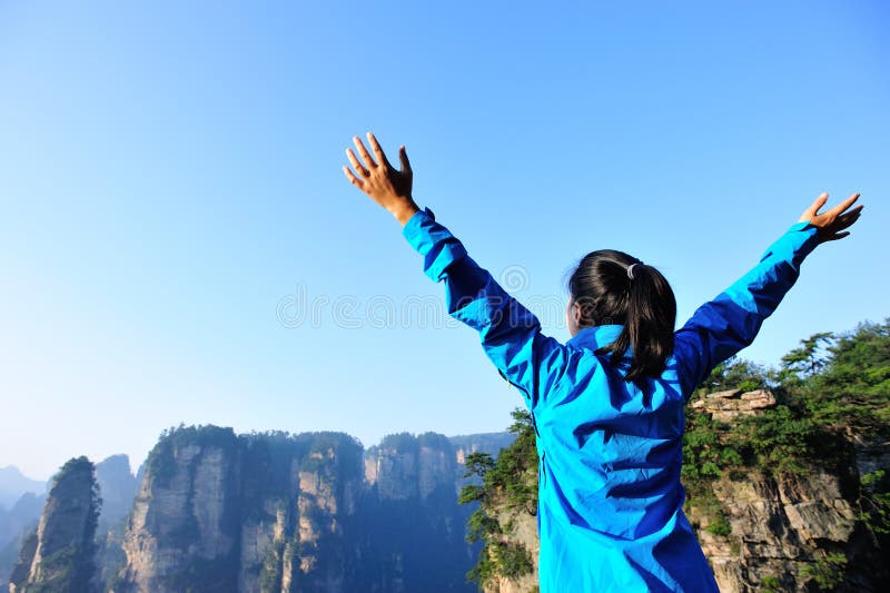 Woman tourist open arms at mountain peak zhangjiaj