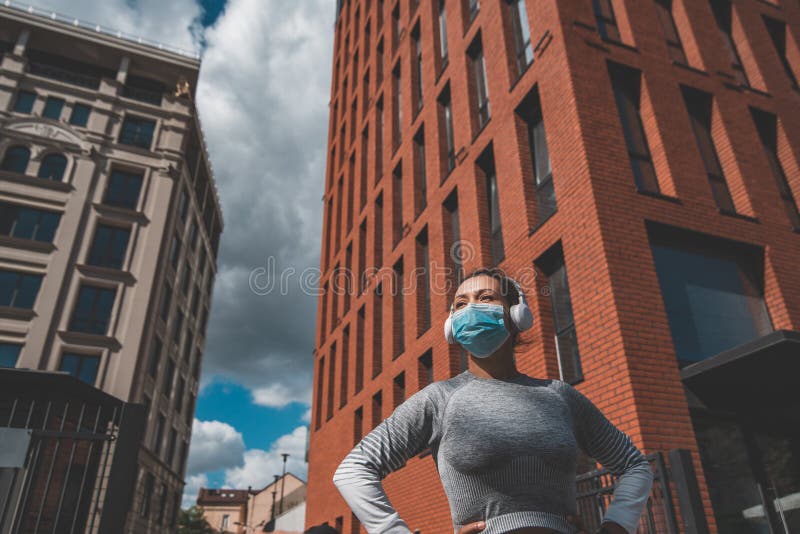 A woman in tracksuit stands in front of buildings stock photo