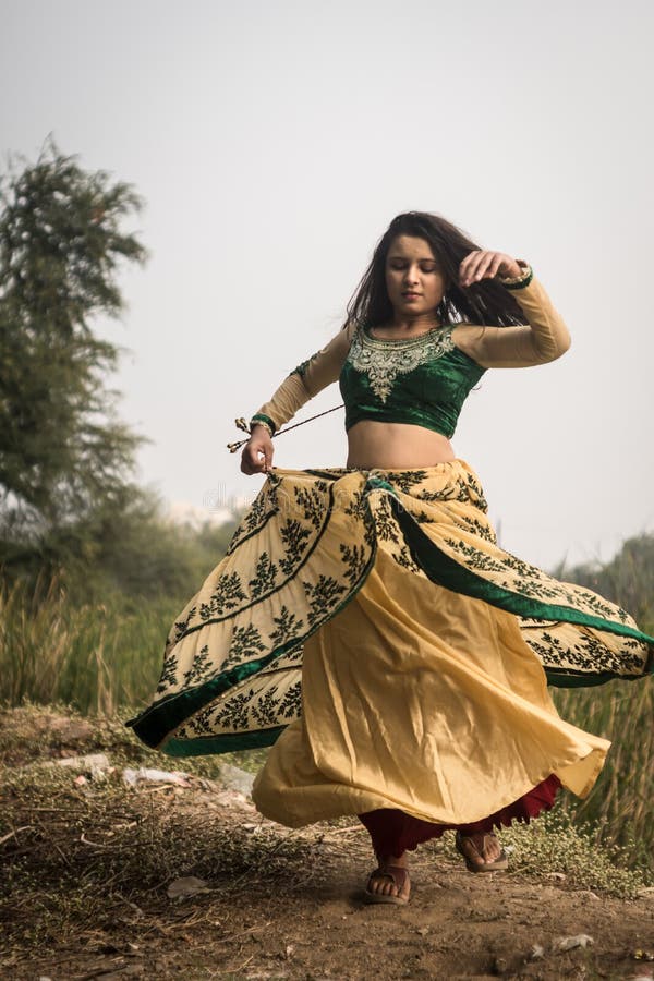 Beautiful young girl in an Indian dress dancing along the road Stock Photo  | Adobe Stock