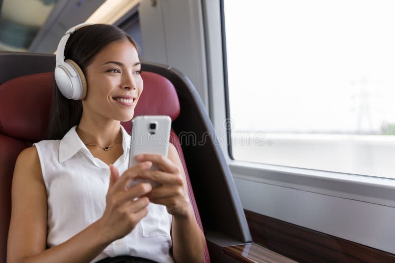 Woman on train listening to music on smartphone. People lifestyle. Young urban businesswoman using phone app, wireless stock image Woman on train listening to music on smartphone. People lifestyle. Young urban businesswoman using phone app, wireless stock image