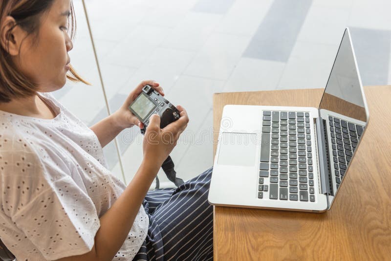 Woman transfer image data on camera to laptop stock image